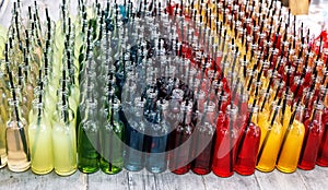 Colorful cocktails, shots with straws in small glass bottles