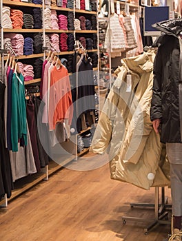 A colorful collection of women`s autumn and winter clothing hangs on a hanger in the store