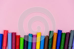 Colorful of color pen isolated on pink background. bright colored markers with caps lie on a pink table
