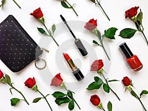 Colorful composition with red bright roses and woman accessories. Flat lay on white table, top view