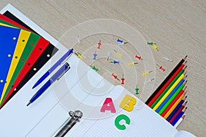 Colorful composition of school supplies and letters on the withe wooden background. Copy space. Flat lay. Back to school