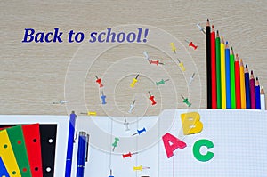 Colorful composition of school supplies and letters on the withe wooden background. Copy space. Flat lay. Back to school