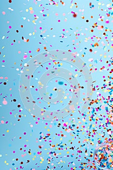 colorful confetti falling over blue background