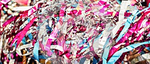 Colorful confetti and streamer lying on floor in fron of background. Festive background of confetti. Trendy neon pink purple blue