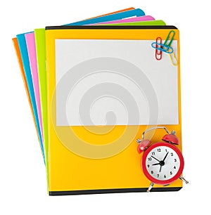 Colorful copybooks with empty card and alarm clock