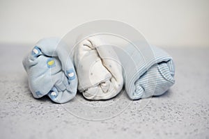 Colorful cotton folded clothes stack on white table empty space background,baby laundry.