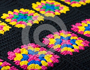 Colorful cotton granny square. Crochet texture close up photo