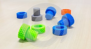 Colorful Creative Plastic Nuts Bolts and Rings made by 3D Printer on Wooden Table
