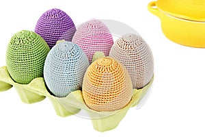 Colorful crocheted eggs in a box