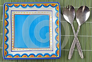 Colorful crockery with old cutlery