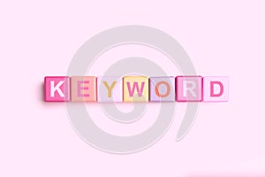 Colorful cubes with word KEYWORD on pink background