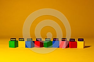 colorful cubes with words that convey a nice positive message, yellow background