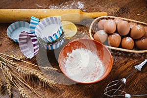 Colorful cupcake wrappers with baking pan on wooden background