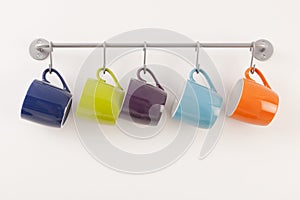 Colorful cups on metal rack