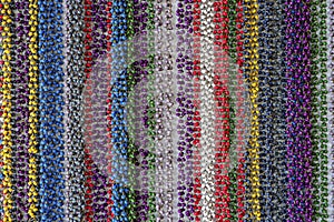 Colorful curtain of multi-colored beads hangs at a local street market in Hoi An, Vietnam, closeup