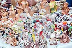 Colorful cute souvenir decorative clay bells, wind chimes, toys, dolls, figurines of animals and people. Handmade souvenir