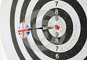 Colorful darts board close up with arrows in the bullseye. Flag