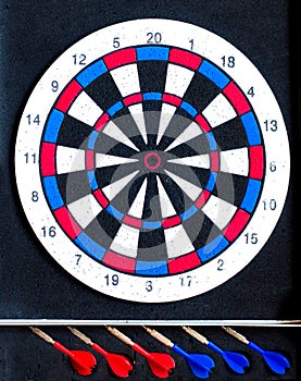 Colorful darts board close up with arrows in the row