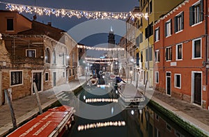 Venice, Italy February 18 , 2020.Colorful decorated alley with christmas lights view fromthe  Ponte dei Pugni bridge photo