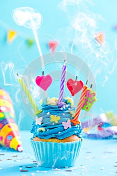 Colorful decorated cupcake with candles blow up