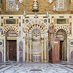 Colorful decorated marble wall with Mihrab and wooden minbar at mosque of Sultan Barquq, Cairo, Egypt