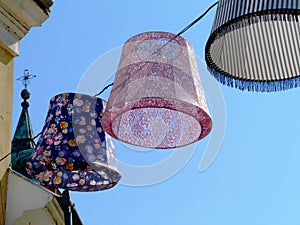 colorful decorative lampions or lamp hoods suspended on electrical wire overhead