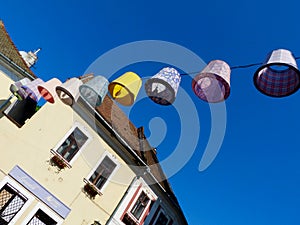 Colorful decorative lampions or lamp hoods suspended on electrical wire overhead