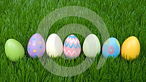 Colorful easter eggs in a row on green grass
