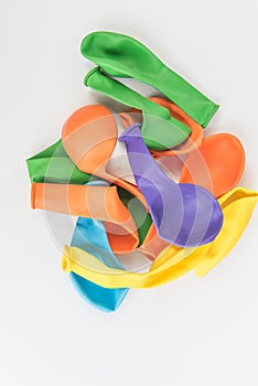 Colorful deflated balloons on white background