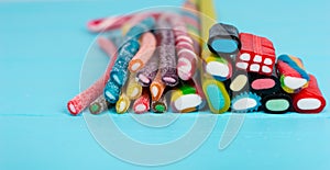 Colorful delicious licorice and chewy candies on wooden board