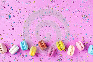 Colorful dessert macaron or macaroon on pink punchy background top view. Flat lay