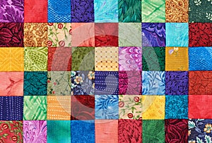 Colorful detail of quilt sewn from square pieces