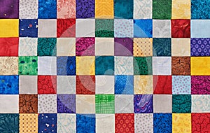 Colorful detail of quilt sewn from square pieces