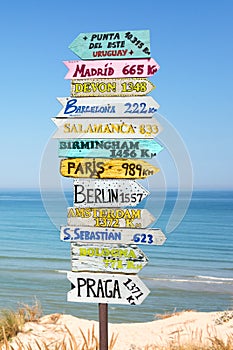 Colorful directions signs on the beach to different places of the world Travel concept