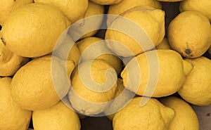 Colorful Display Of Lemons in a basket at bio market or grocery store. Organic Fresh lemons background close up.