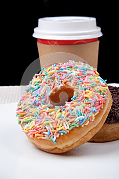 Colorful Donuts and coffee in white plate with black background