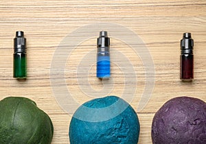 Colorful dough and bottles with food colorings on table, flat lay