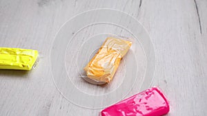 Colorful dough plasticine is falling on wooden table