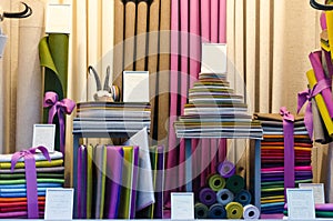 The colorful drapery shop window with fabric rolls and stacks of different shapes and colors