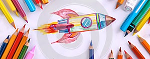 Colorful Drawing of a Rocket with Pencils on White Background. Creativity in Education Concept. Child Art Project