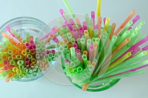 Colorful drinking straws for celebrations in green and clear glass
