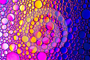 Colorful drops of oil on the water. Rainbow or spectrum colored circles. Abstract bright background for design