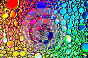Colorful drops of oil on the water. Rainbow or spectrum colored circles. Abstract bright background for design
