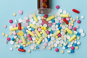 Colorful drug pills on blue background, pharmaceutical concept