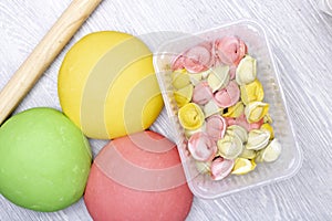 Colorful dumplings, pelmeni from red, green and yellow dough in container