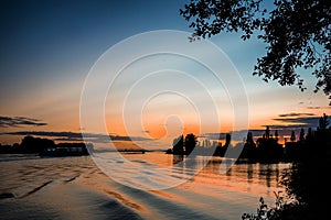 Colorful and dusky skies greet a barge floating down river