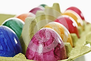 Colorful, dyed Easter eggs in carton