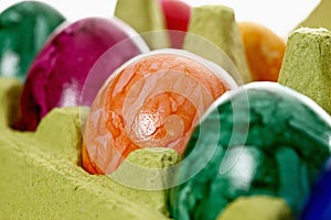 Colorful, dyed Easter eggs in carton