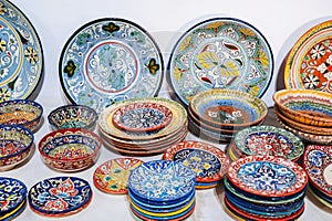 colorful east Uzbek ceramic plates hand-painted at oriental souvenir tableware bazaar