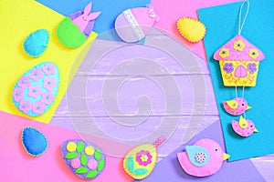 Colorful Easter background. Creative felt Easter crafts on felt sheets and on lilac wooden background with copy space for text